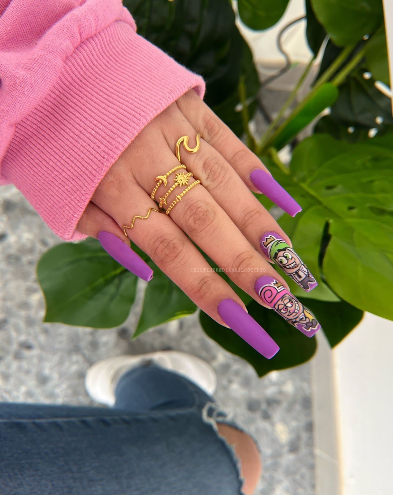Uñas largas moradas con un diseño de grafiti pintado a mano
